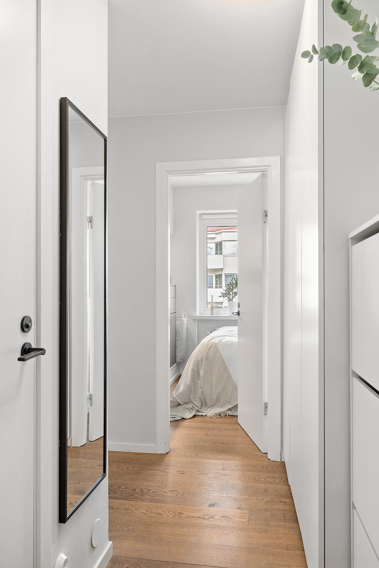 Hall med vy till sovrum. Badrummet är till vänster