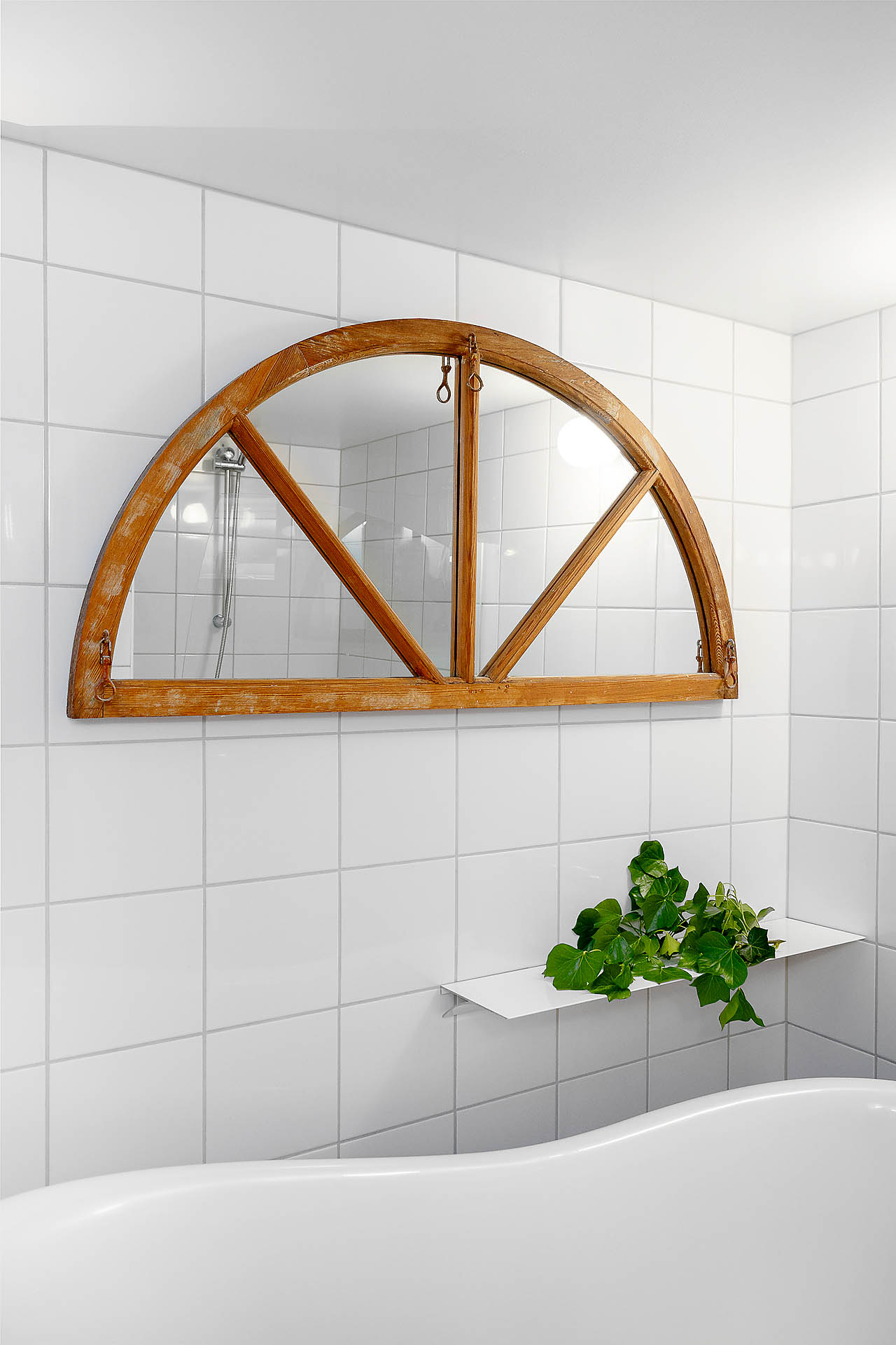 Snygg spegel och en praktiskt hylla när du tar dig ditt bad