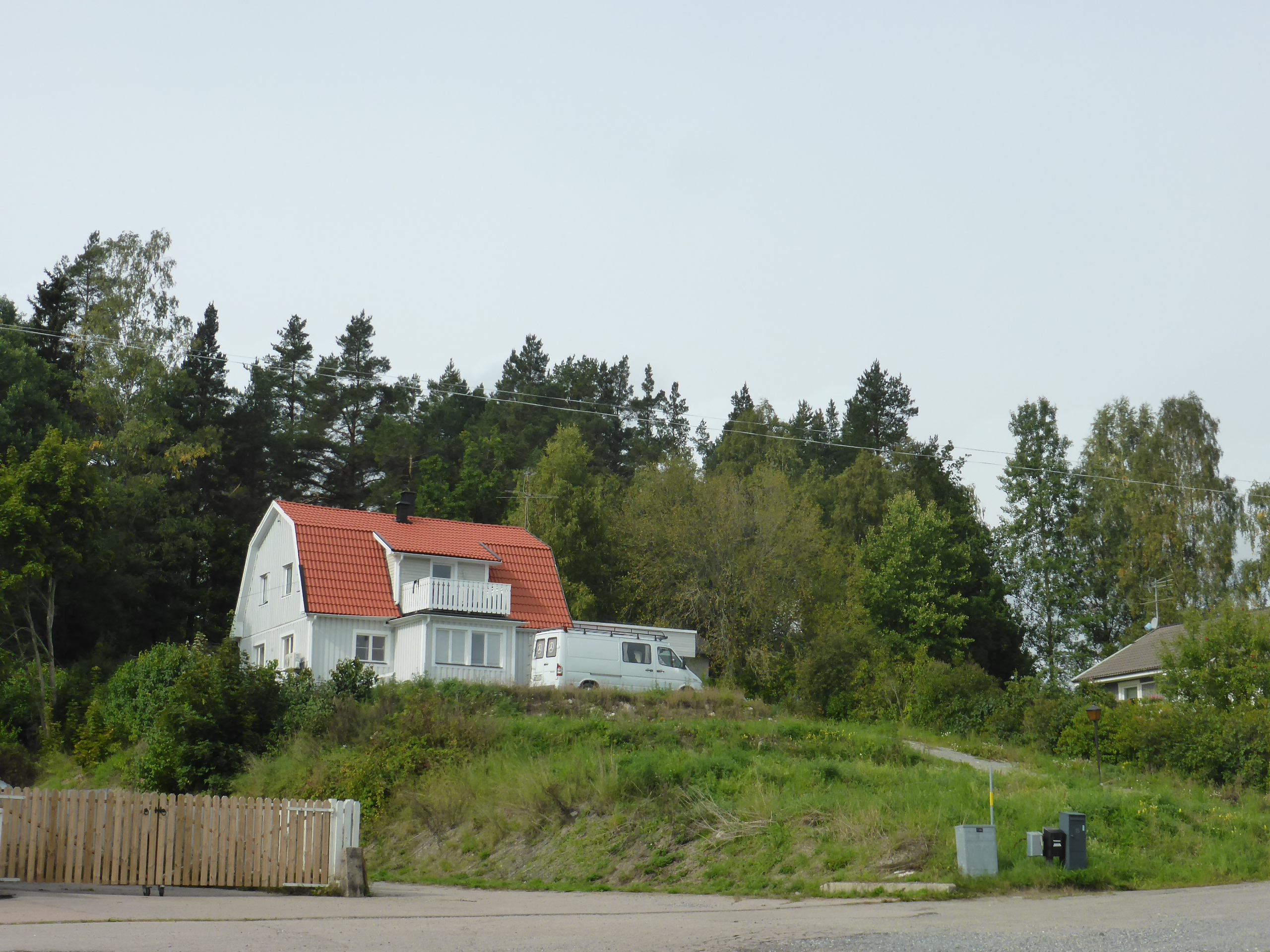 Tomten ligger bakom det vita huset med högt läge