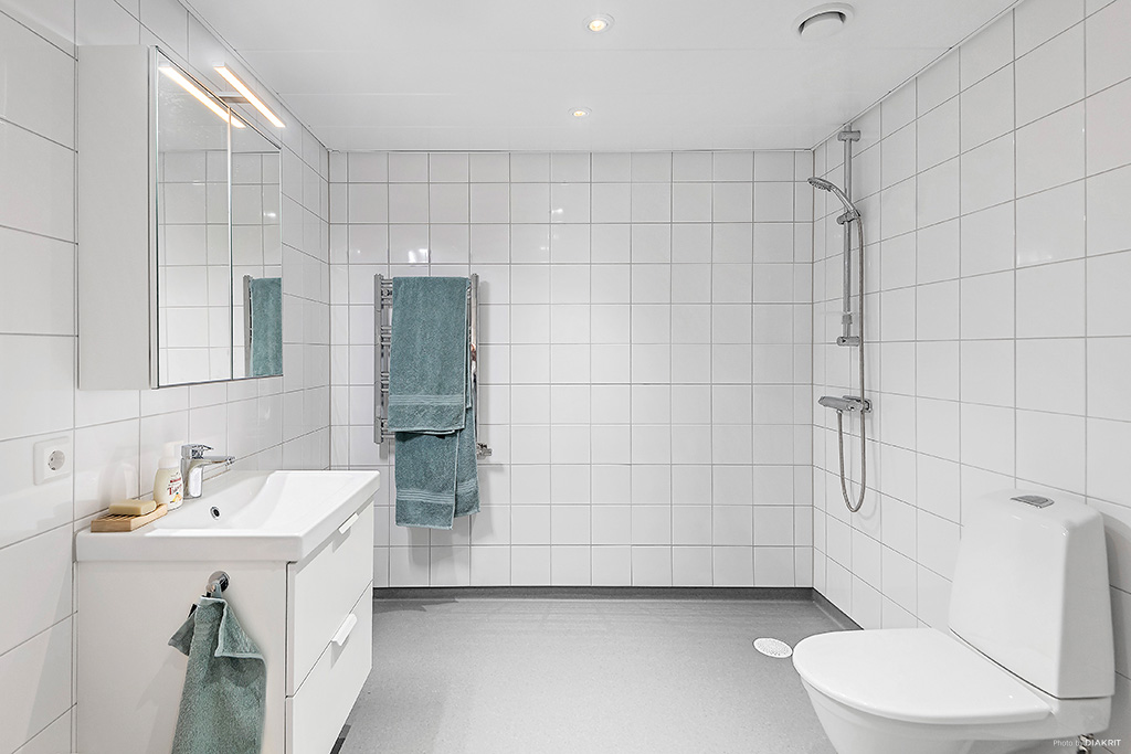 Generöst tilltaget badrum med tvättmaskin