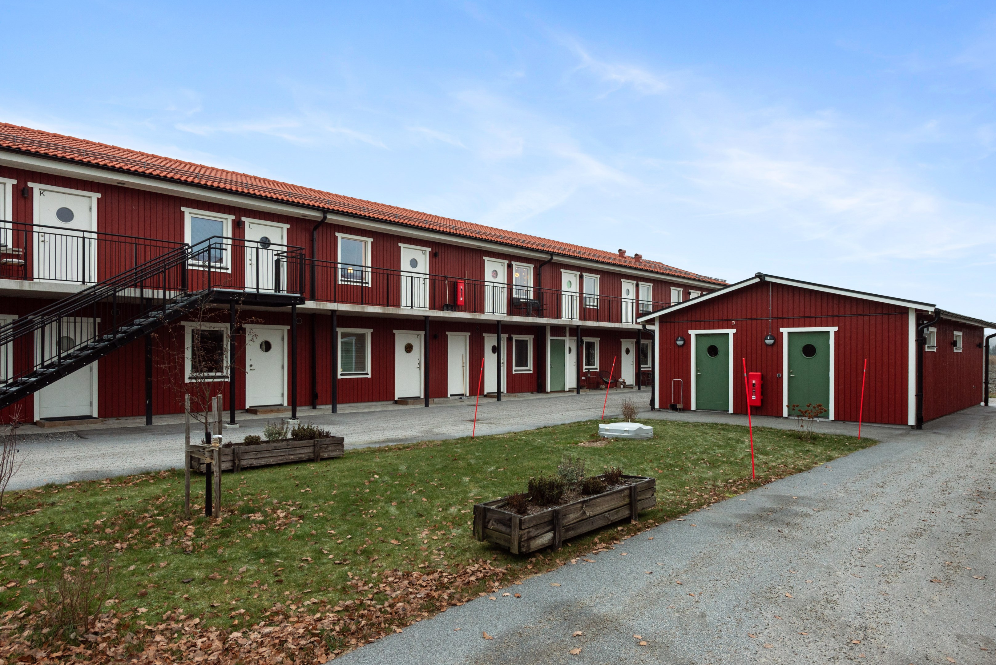Husets framsida och gårdshus med tvättstuga