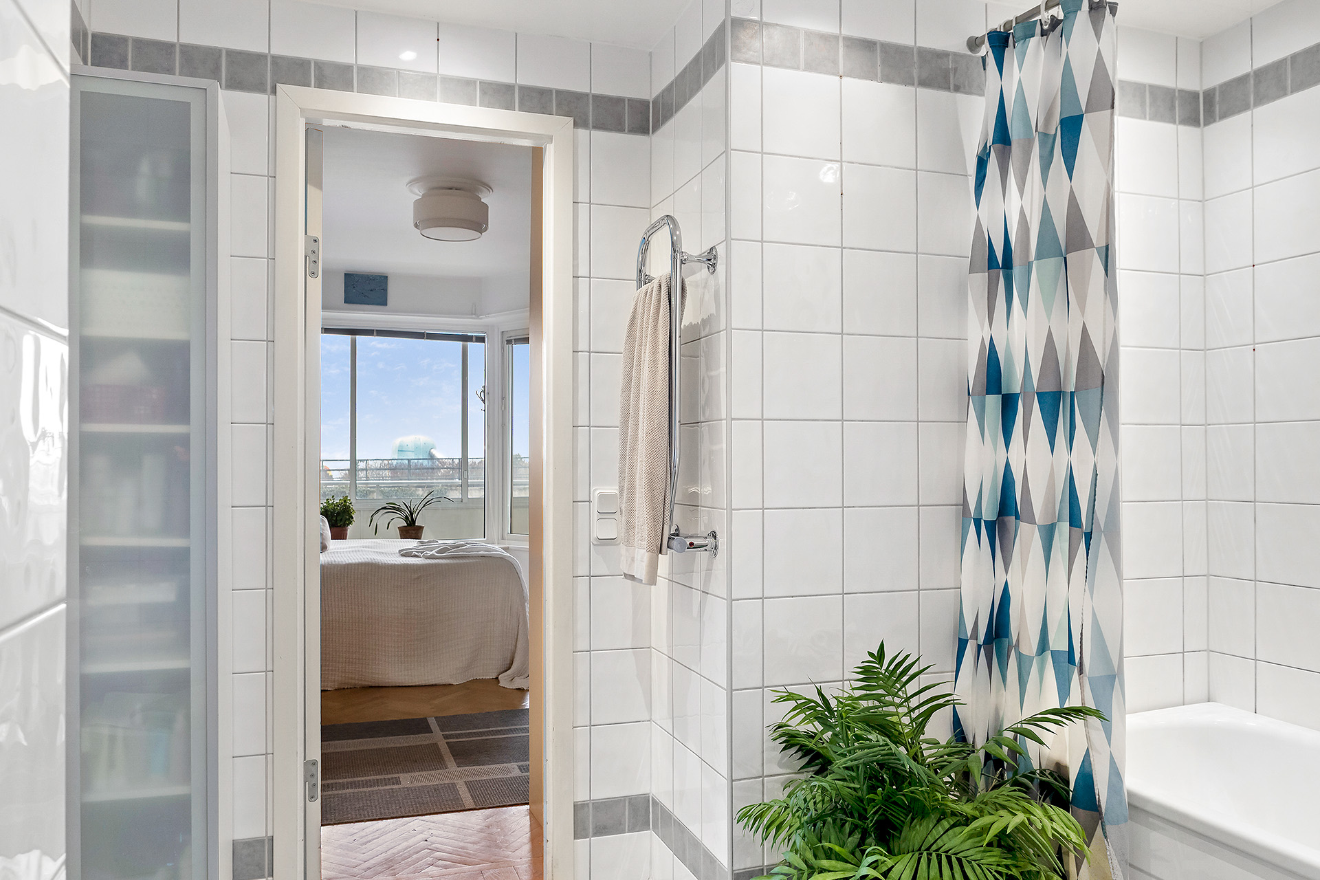 Badrum med badkar och 2 dörrar, en mot sovrum och en mot hall