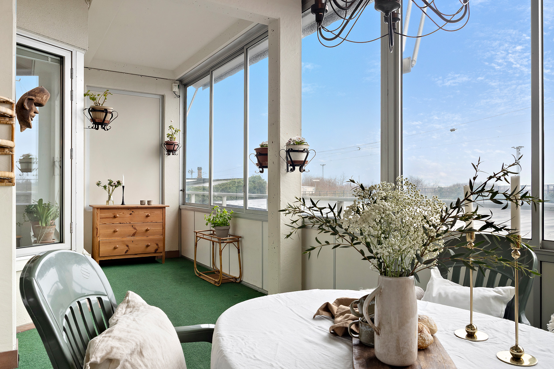 Stor inglasad balkong med klinker på golvet