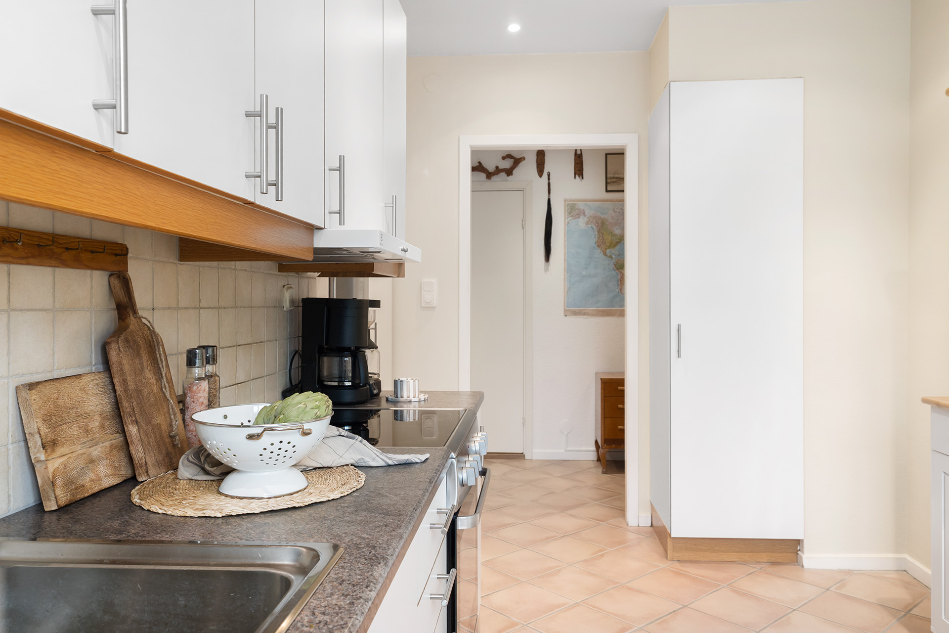 Kök med klinker på golvet och infällda spotts i taket