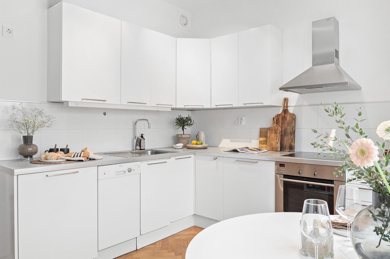 Kök med vägghängd fläkt, diskmaskin och integrerad kyl/frys