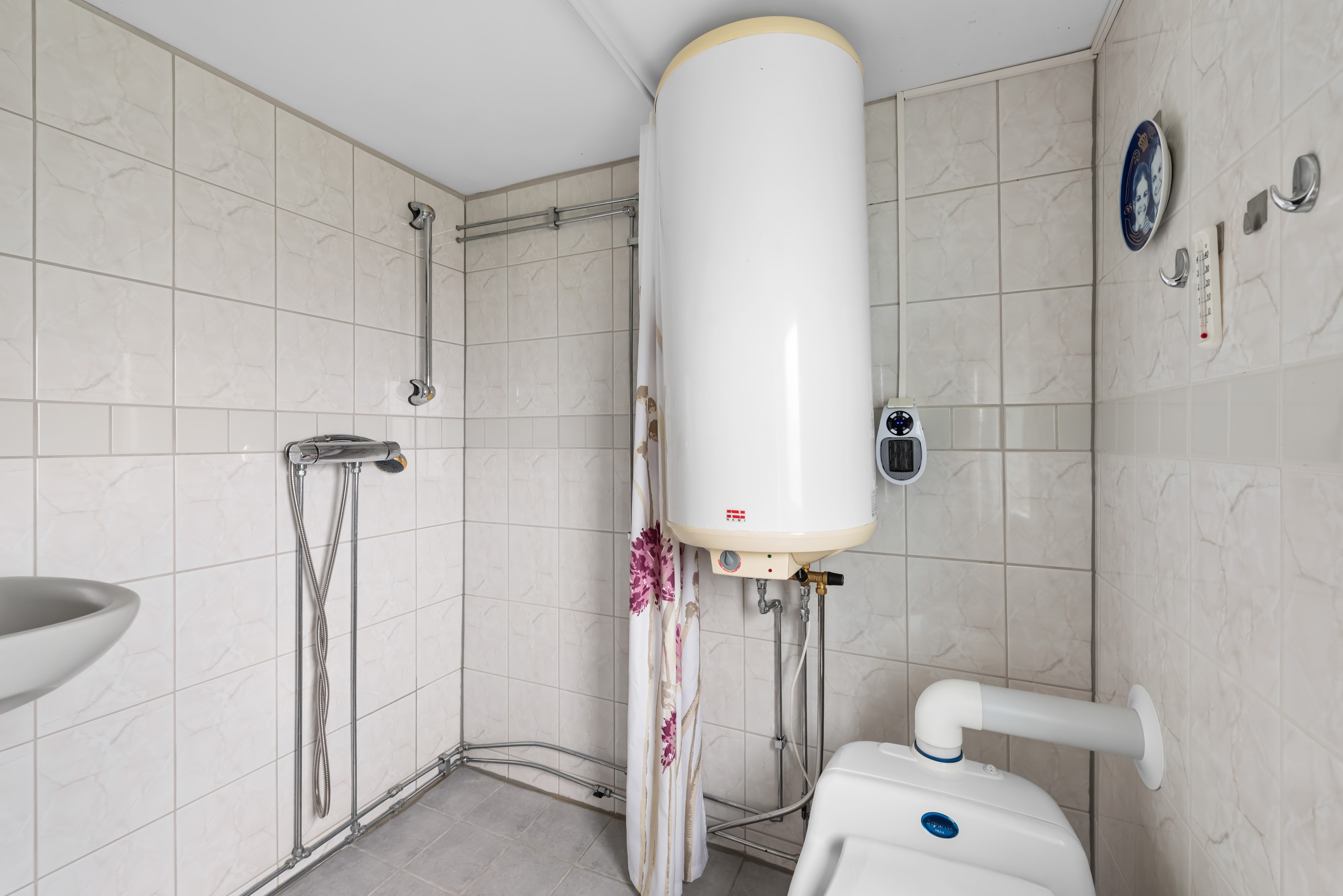 Badrum med dusch, tvättfat, spegelskåp och toalett