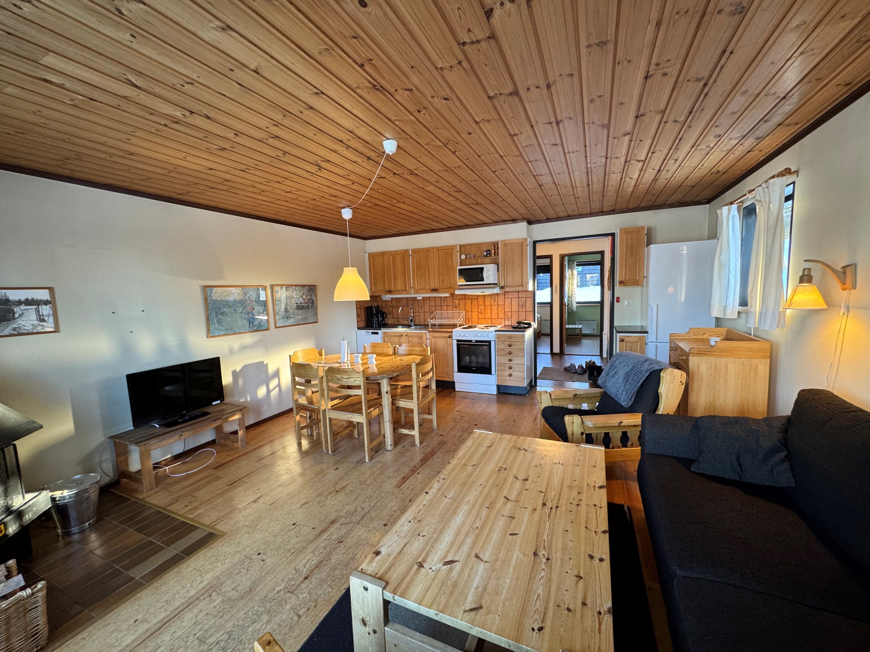 Storstuga med eldstad och utgåmg till altan.