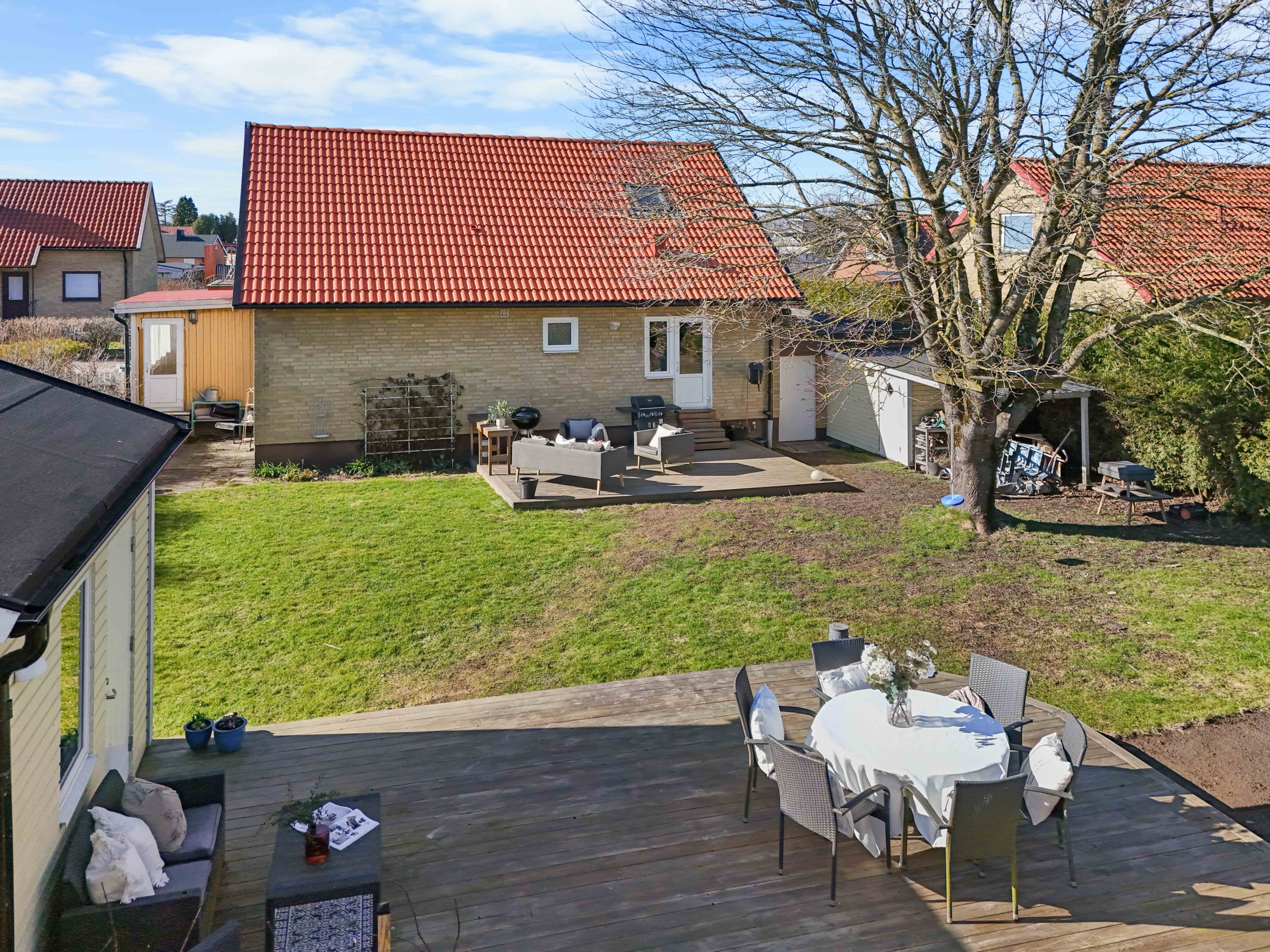 Vy från husets baksida och trädgård