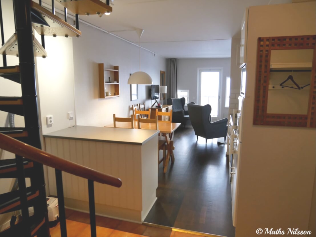 Lägenheten har ett ljust vardagsrum med matplats och sittgrupp