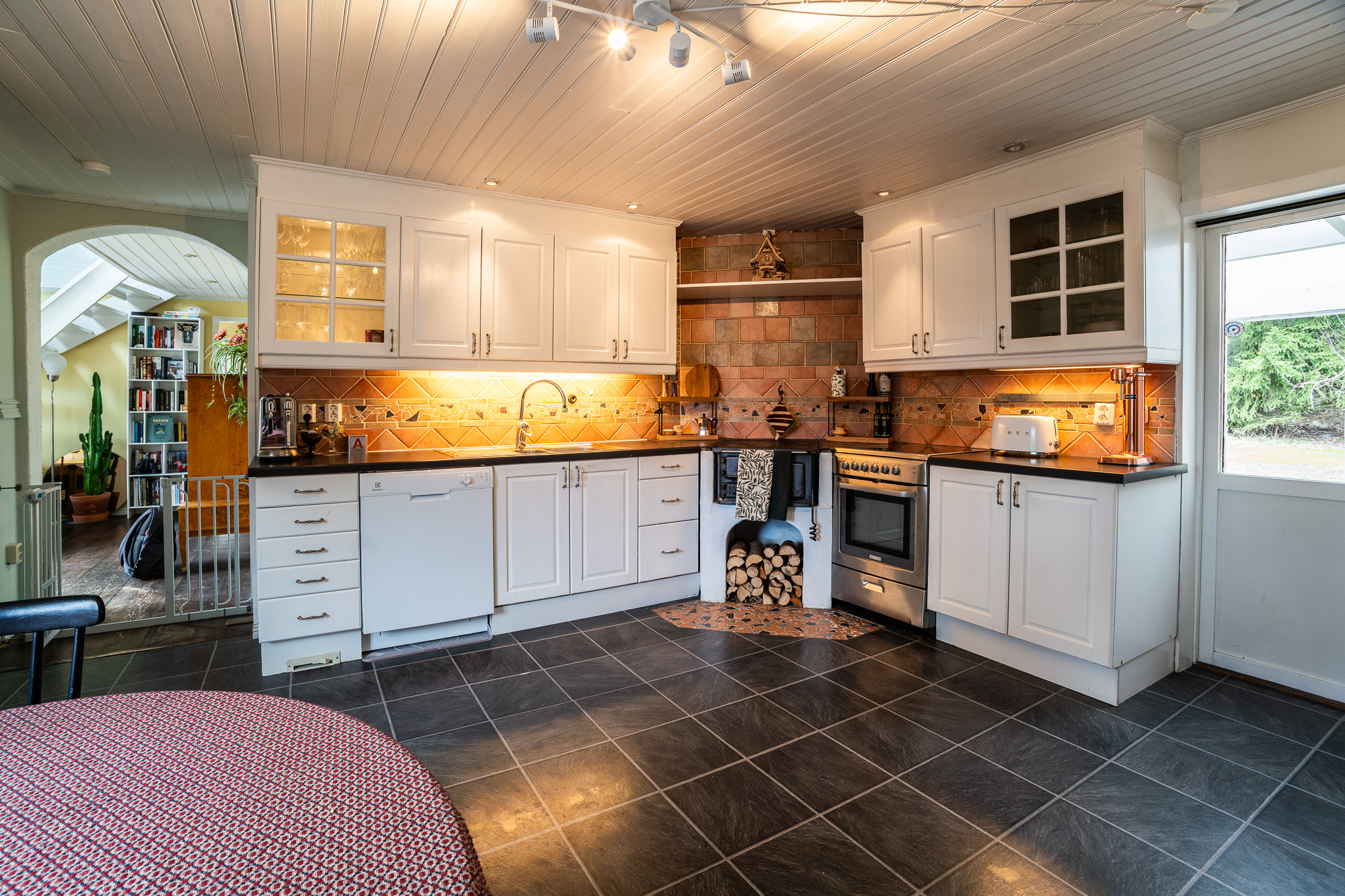 Ett kök med vedspis och plats för matbord