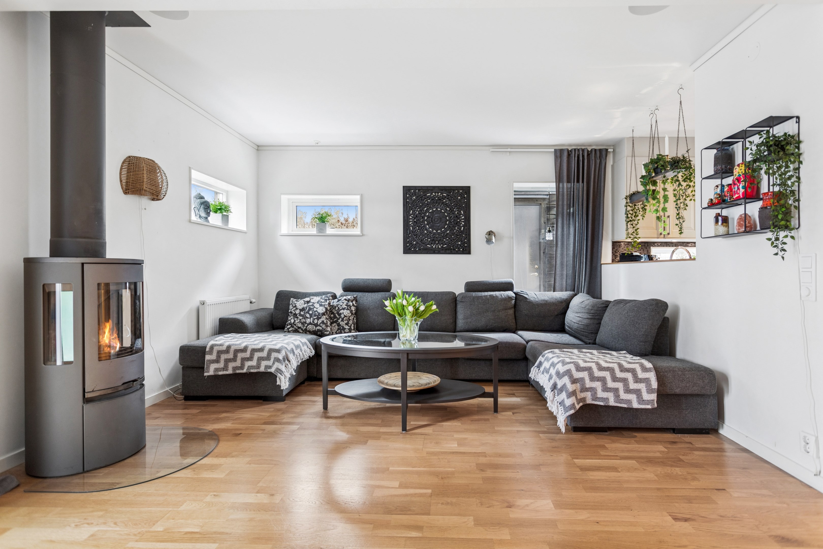 Rejält vardagsrum med braskamin och delvis öppet mot kök