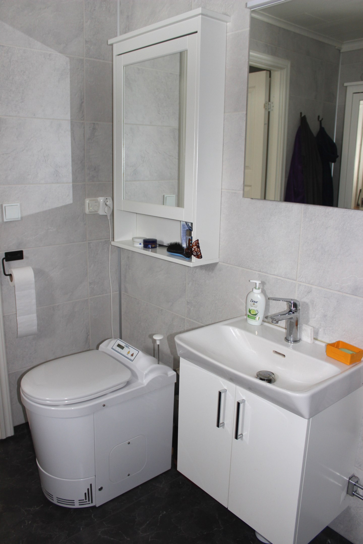 Handfat, el-toa och badrumsskåp.