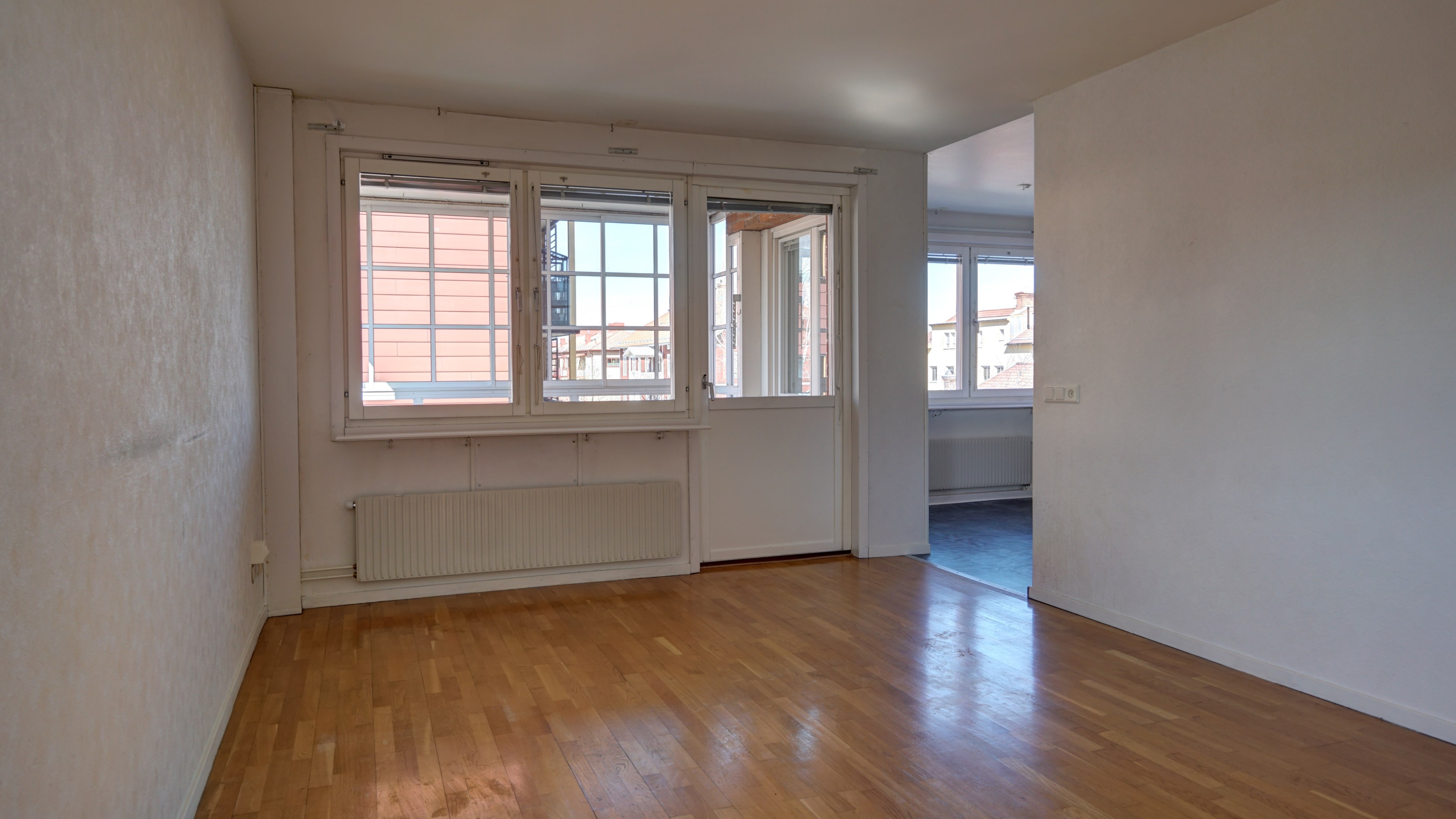 Vardagsrum mot inglasad balkong och kök