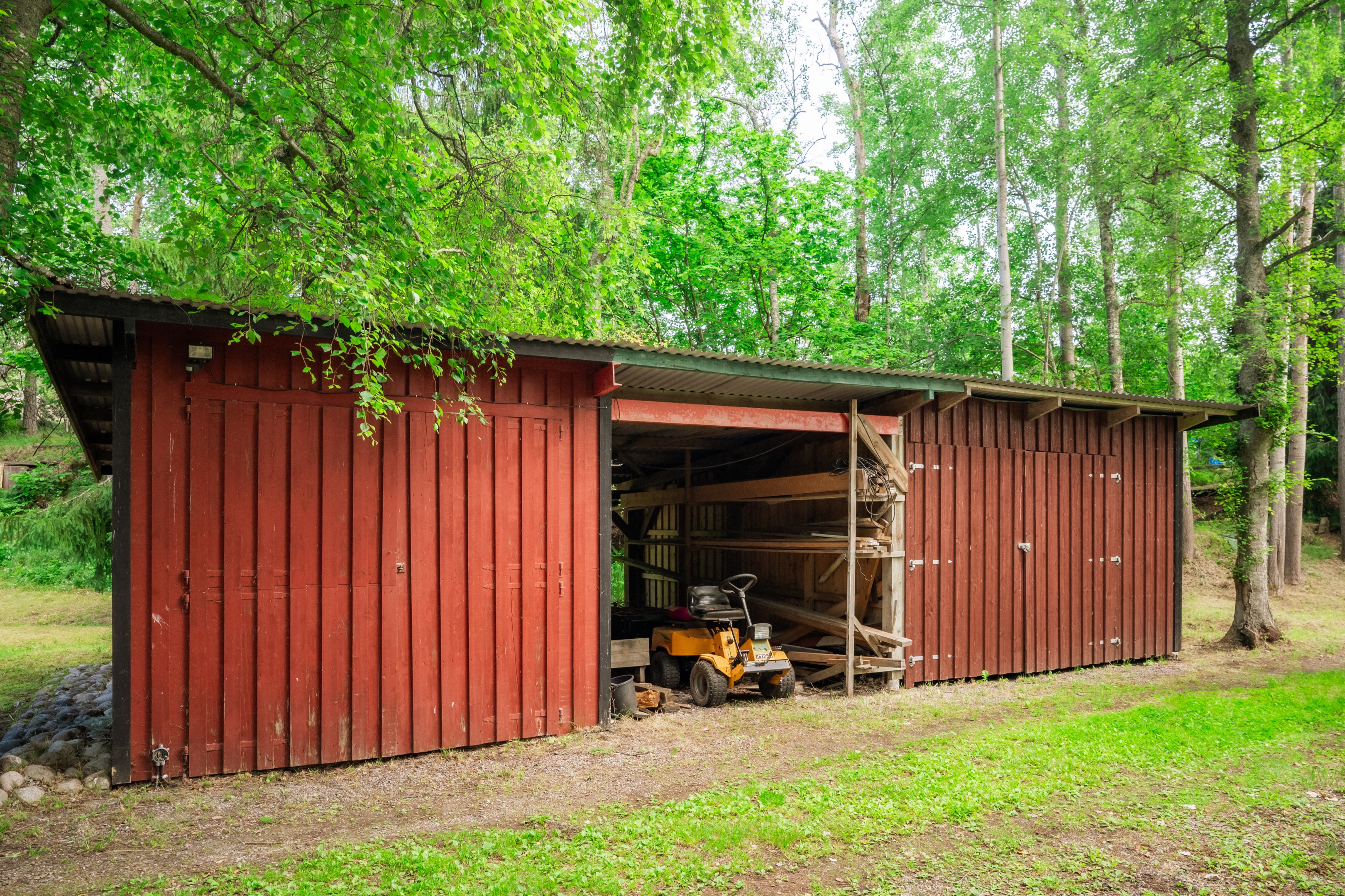 Maskinhall med carport och garage varav det ena tidigare nyttjats som stall
