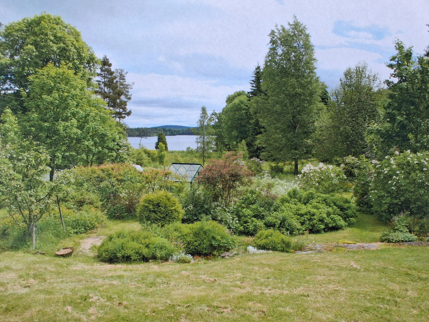 Utsikt över trädgård och sjön från verandan