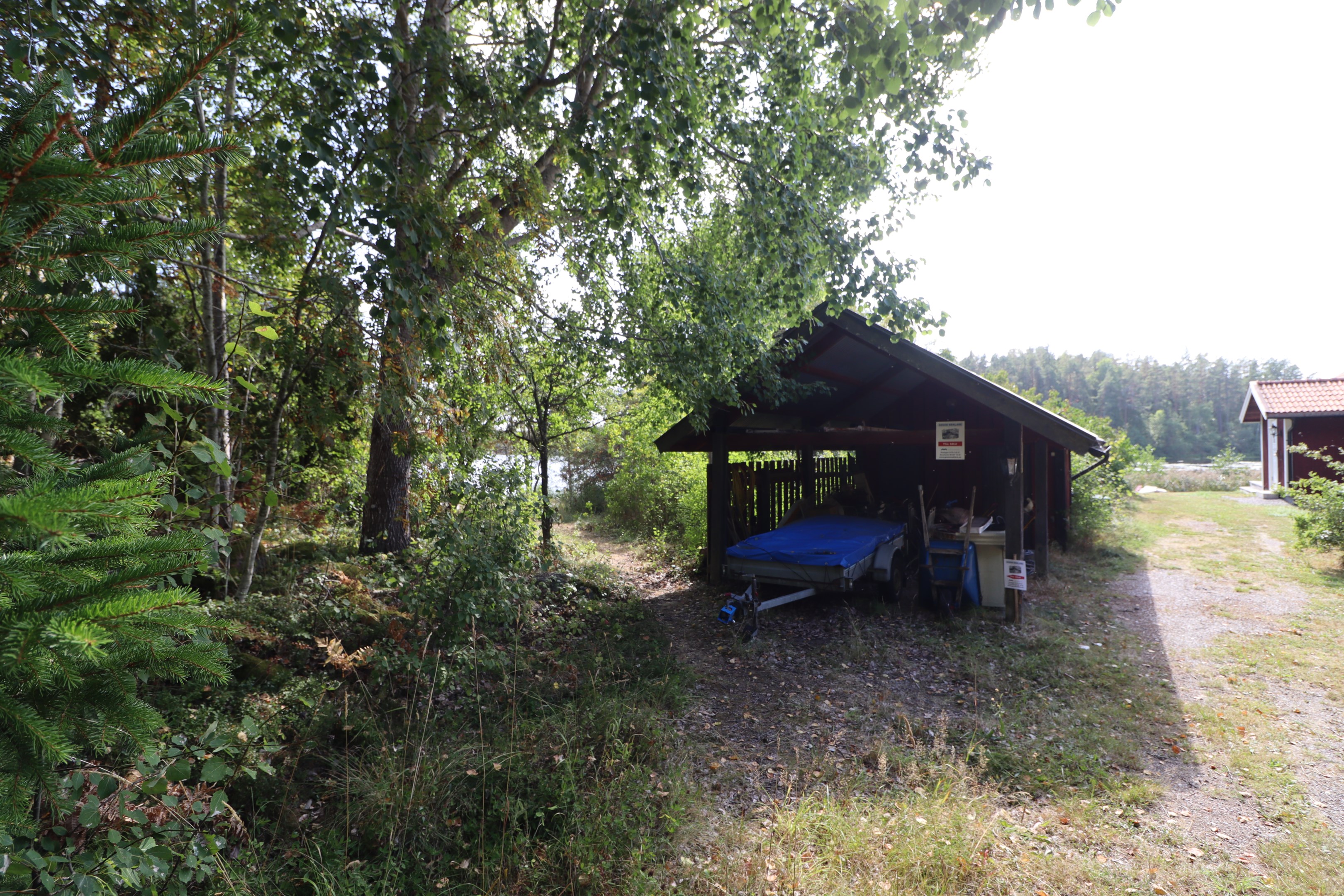 Carport med förråd som står på 3:27, gångväg till huset till vänster