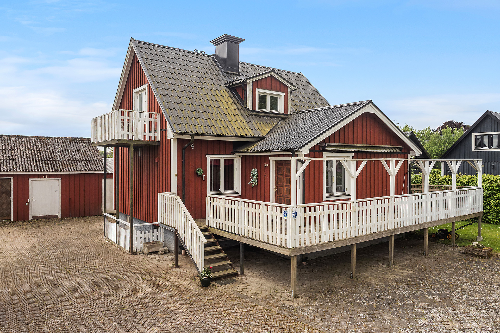 Trevligt rött trähus med terrass runtomkring huset