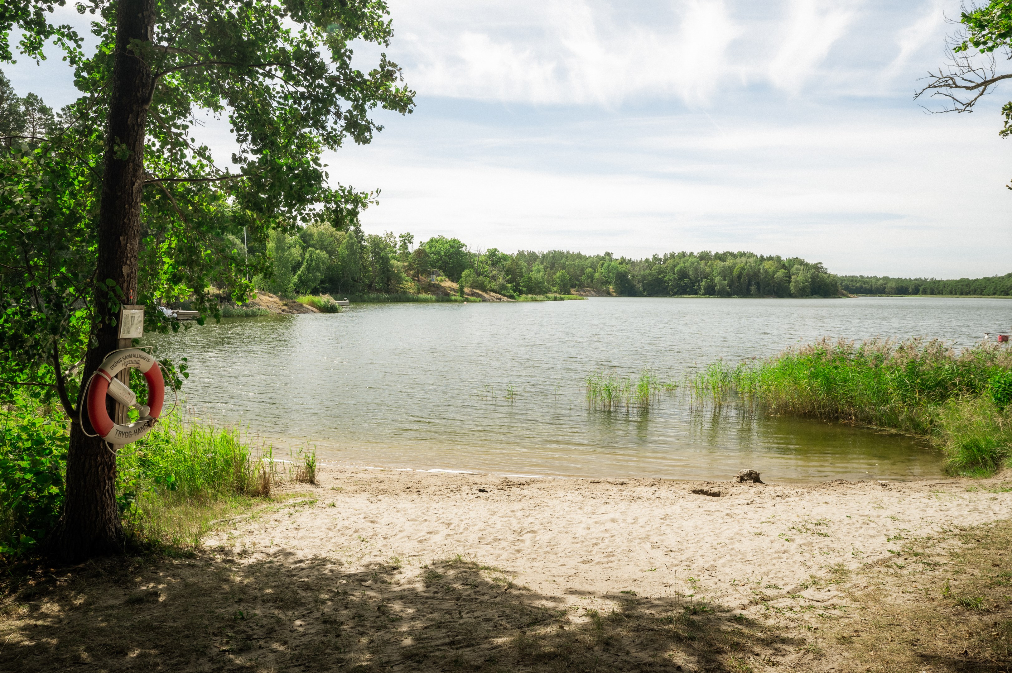 Kort promenad till mysig badstrand i viken snett nedanför tomtgräns