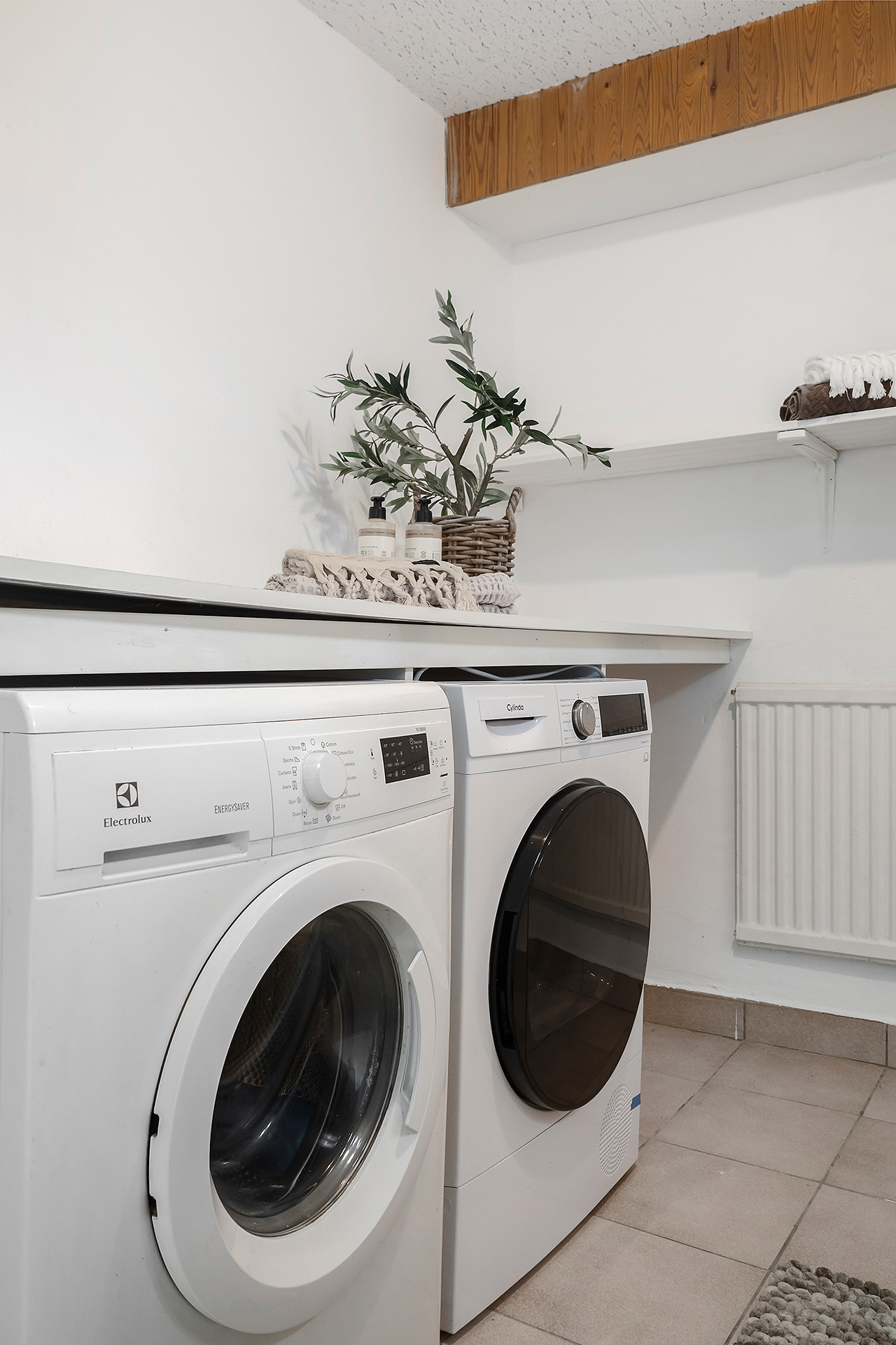 Tvättstuga med tvättmaskin (Electrolux) och torktumlare (Cylinda)