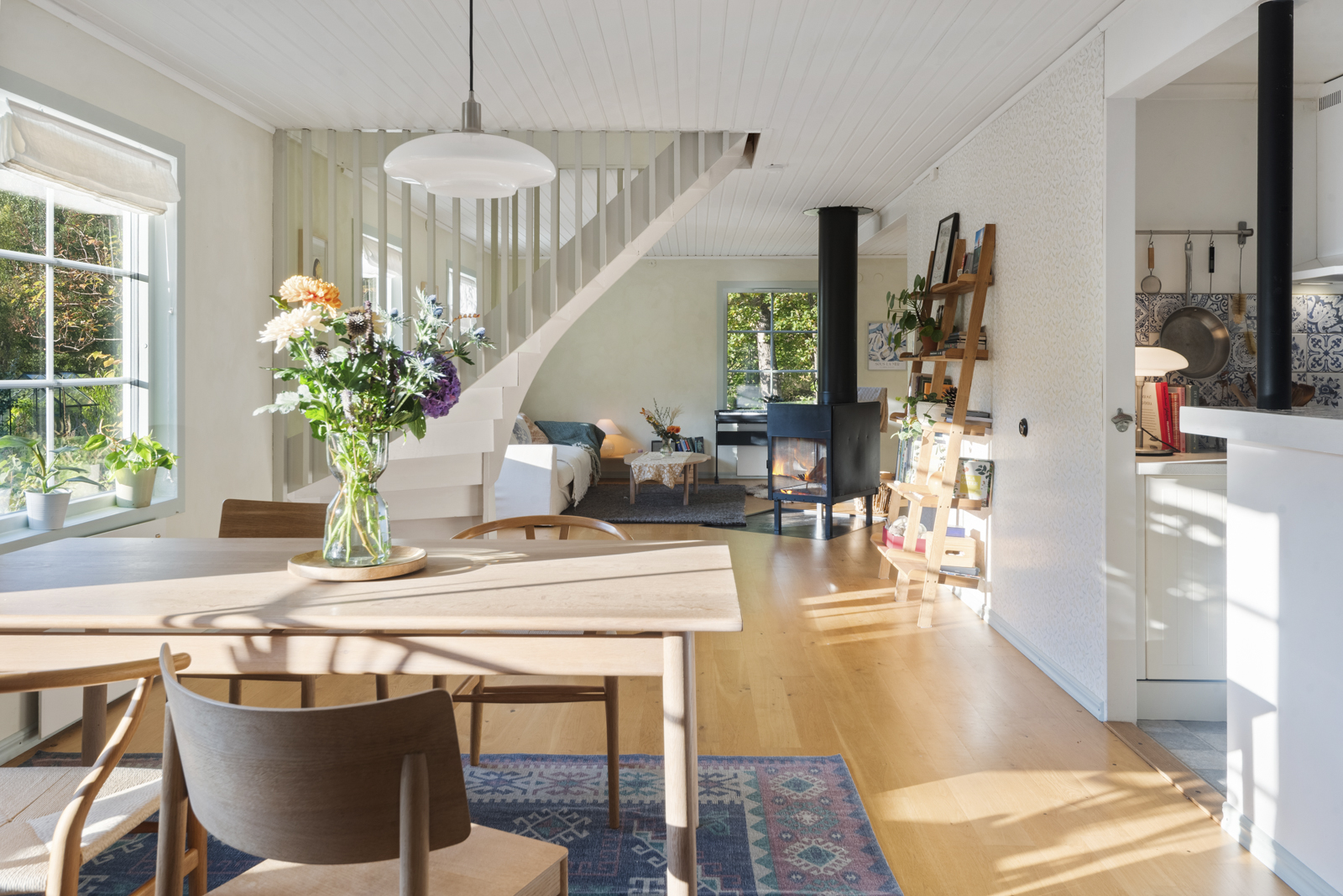 Ljus öppen planlösning med eldstad och trevligt kök med barhäng