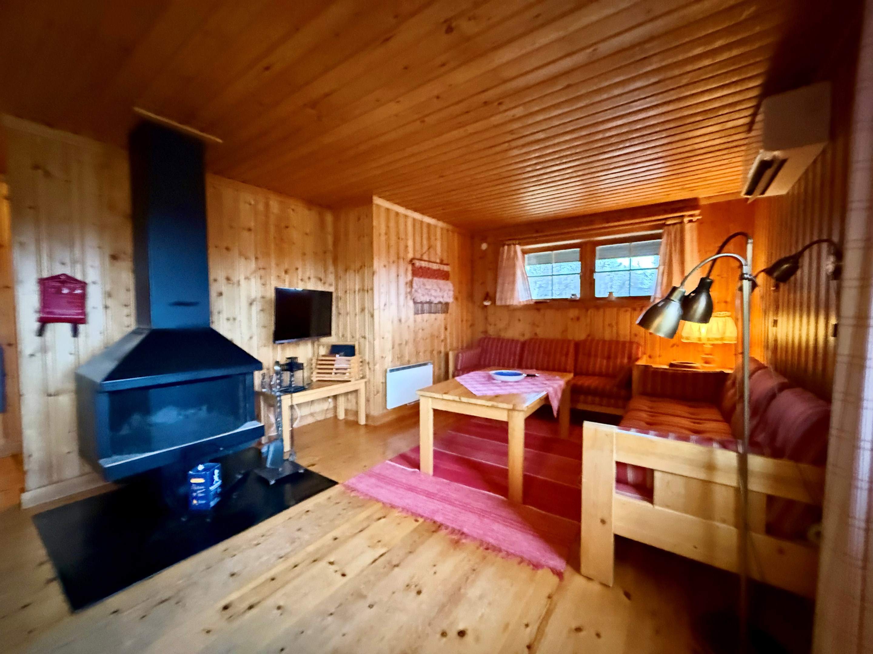 Storstuga med soffhörna och eldstad exempelbild från liknande hustyp Fjällsippa